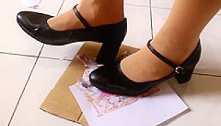 Girl stomping on paper in high heels, crushing trampling picture in heels